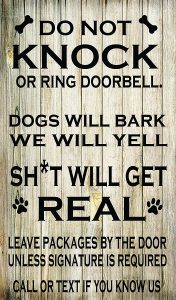 humorous sign requesting people do not knock or ring the doorbell so as not to disturb the dogs